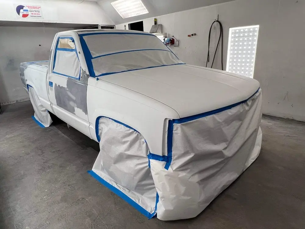 Pickup truck masked with blue tape before painting