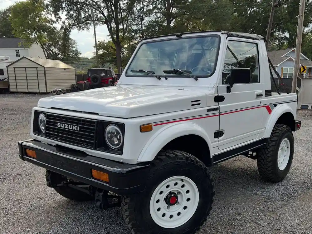 Restored white Suzuki Samurai with red stripes, front view