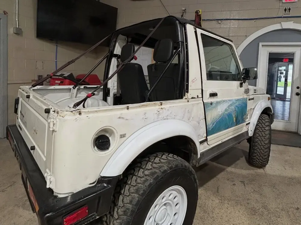 Suzuki Samurai bed and roll bar before restoration in the shop